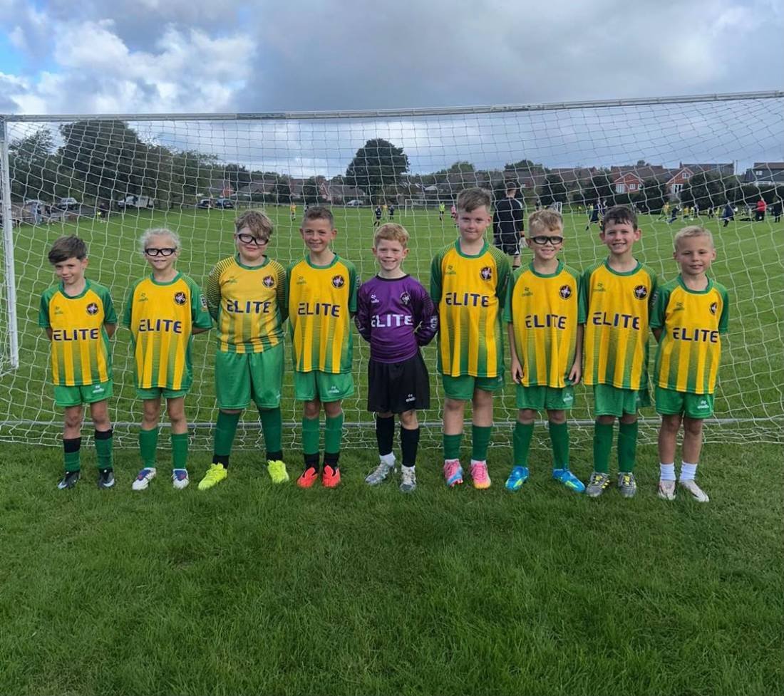 Aspull Sharks Under 9s football team in green and gold kits sponsored by Elite Construction